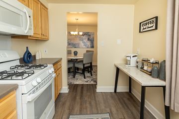 Baltimore apartment for rent - A kitchen with a white stove and a white microwave above it.