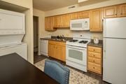 Pikesville apartment for rent - A kitchen with wooden cabinets and white appliances at The Brittany Apartments, MD