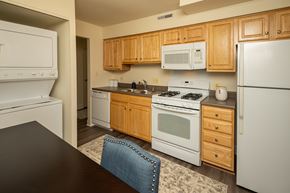 Pikesville apartment for rent - A kitchen with wooden cabinets and white appliances at The Brittany Apartments, MD