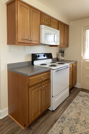 Essex apartment for rent - Wooden kitchen cabinets with white microwave and oven with gas range at Walnut Grove Townhomes*, Maryland
