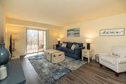 Baltimore apartment for rent - A living room with a sofa, a chair, and a rug at Liberty Gardens Apartments, Baltimore, Maryland