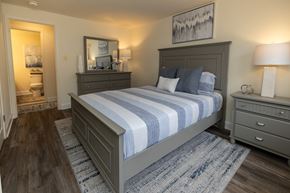 Towson apartment for rent - A bedroom with a large bed and a painting on the wall.