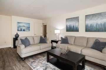 Towson apartment for rent - A living room with a couch, coffee table, and two paintings on the wall.