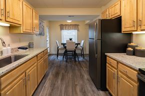 Towson apartment for rent - A kitchen with wooden cabinets and a black refrigerator.