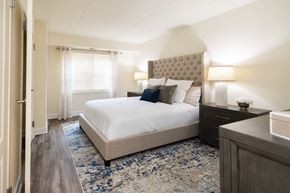 Towson apartment for rent - A bedroom with a large bed and a wooden dresser.