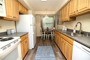 Baltimore apartment for rent - A kitchen with wooden cabinets and a white refrigerator.