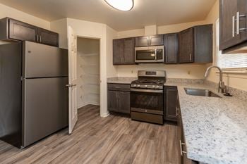 A kitchen with a refrigerator freezer and a stove top oven