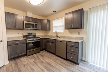 Baltimore apartment for rent - a kitchen with dark wood cabinets and stainless steel appliances