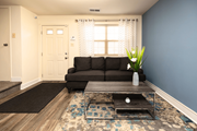 Baltimore apartment for rent - A living room with a grey couch, a coffee table, and a rug at Kingston Townhomes, Baltimore, MD