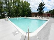 Owings Mills apartment for rent - A large swimming pool surrounded by trees and chairs at Painters Mill Apartments, Owings Mills, 21117