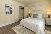 Pikesville apartment for rent - A bedroom with a large bed, two nightstands, and a rug at The Brittany Apartments, Pikesville, Maryland