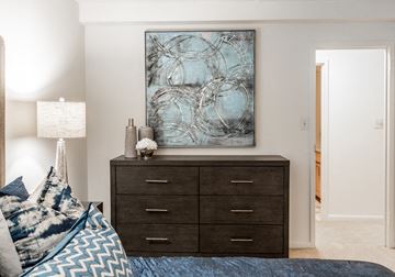 Towson apartment for rent - A bedroom with a bed, a dresser, and a painting on the wall.
