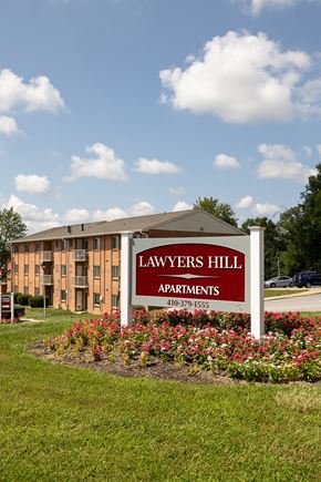 Elkridge apartment for rent - A sign for Lawyers Hill Apartments in front of a building.