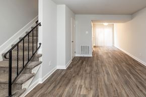 Randallstown apartment for rent - A living room with hardwood floors and a staircase at McDonogh Village Apartments & Townhomes, Randallstown