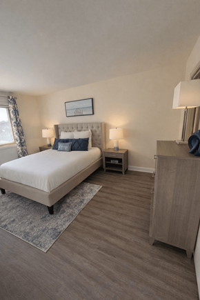 Elkridge apartment for rent - A bedroom with a large bed and a wooden cabinet at Lawyers Hill Apartments, Elkridge, 21075