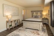 Baltimore apartment for rent - A bedroom with a large bed and a painting on the wall at Liberty Gardens Apartments, Maryland