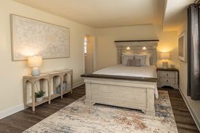 Baltimore apartment for rent - A bedroom with a large bed and a painting on the wall at Liberty Gardens Apartments, Maryland