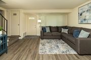 Severn townhouse for rent - A living room with a brown couch and a blue rug at The Orchards at Severn Townhomes*, Severn, MD 21144.