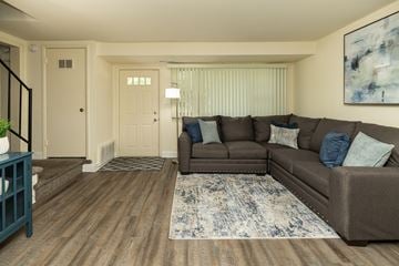 Severn townhouse for rent - A living room with a brown couch and a blue rug.