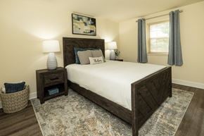 Severn townhouse for rent - A bedroom with a large bed and a painting on the wall at The Orchards at Severn Townhomes*, Severn, MD 21144.