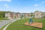 Baltimore apartment for rent - A playground with a green and blue slide in the middle of a grassy area.