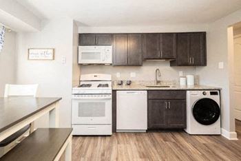 Kitchen with dark wood cabinets and white appliances