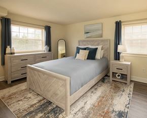Baltimore apartment for rent - A bedroom with a large bed, nightstands, and a rug.
