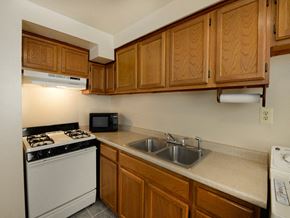 Hanover apartment for rent - Kitchen with wooden cabinets and white appliances at Yorktowne Townhomes Apartments, Pennsylvania