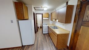 Grand Forks apartment for rent - A kitchen with wooden cabinets and a white refrigerator.