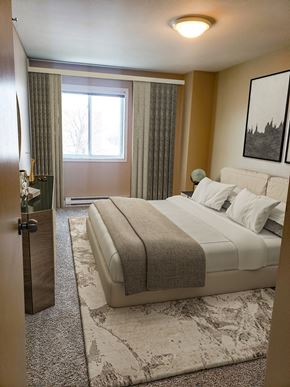 Grand Forks apartment for rent - A bedroom with a large bed and a painting on the wall.