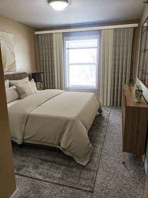 Grand Forks apartment for rent - A bedroom with a large bed and a window with curtains.
