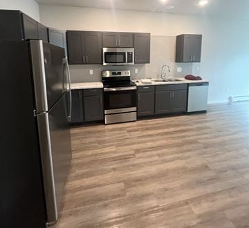 Grand Forks apartment for rent - a kitchen with black cabinets and stainless steel appliances