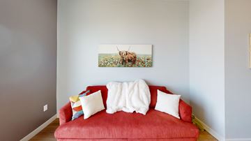 Grand Forks apartment for rent - a living room with a red couch and a picture of a bull