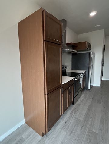 Grand Forks apartment for rent - a kitchen with wooden cabinets and a stove and a refrigerator