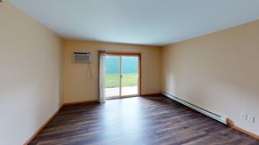Grand Forks apartment for rent - A room with wooden floors and a sliding glass door leading to a green lawn.