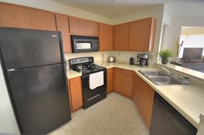 New Berlin apartment for rent - a kitchen with black appliances and wooden cabinets