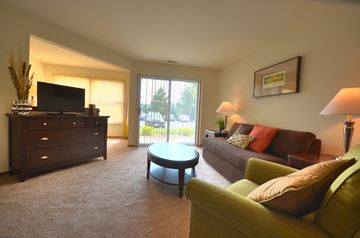 Waukesha apartment for rent - A living room with a green couch and a television.