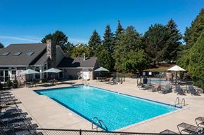 New Berlin apartment for rent - A large swimming pool surrounded by lounge chairs and umbrellas.