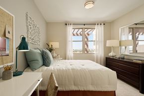 Laguna Hills apartment for rent - A bedroom with a large bed, a desk with a lamp, and a window with curtains.