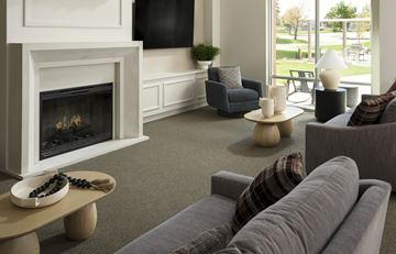 Englewood apartment for rent - A living room with a grey couch and a fireplace.