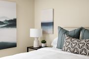 Fountain Valley apartment for rent - A bed with a side table and wall art at Crystal Springs apartments in Fountain Valley.
