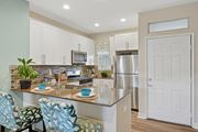 Dublin apartment for rent - A model kitchen with granite counter tops, stainless steel appliances, and counter seating at Park Sierra at Iron Horse Trail in Dublin.