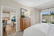 Dublin apartment for rent - A bedroom with a large bed and a dresser with a mirror above it at Park Sierra at Iron Horse Trail in Dublin.