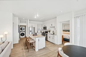Englewood apartment for rent - A modern kitchen with white cabinets and a wooden table.