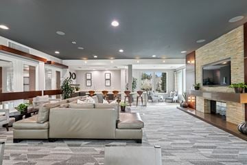 San Jose apartment for rent - A modern living room with a large sectional sofa and a fireplace.