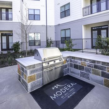 Lavish outdoor deck with grills, an outdoor kitchen, and al fresco dining