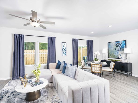 Hoschton apartment for rent - A modern living room with a white sofa, a coffee table, and a ceiling fan.