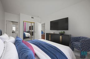 Los Angeles apartment for rent - A bedroom with a bed covered in a white, blue and red comforter.