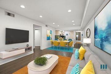 Los Angeles apartment for rent - A modern living room with a grey sofa, yellow chairs, and a large painting on the wall.
