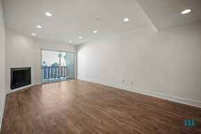 Los Angeles apartment for rent - A spacious room with wooden flooring and a fireplace.